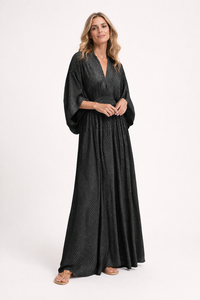 Woman wearing a black patterned dress on a white background