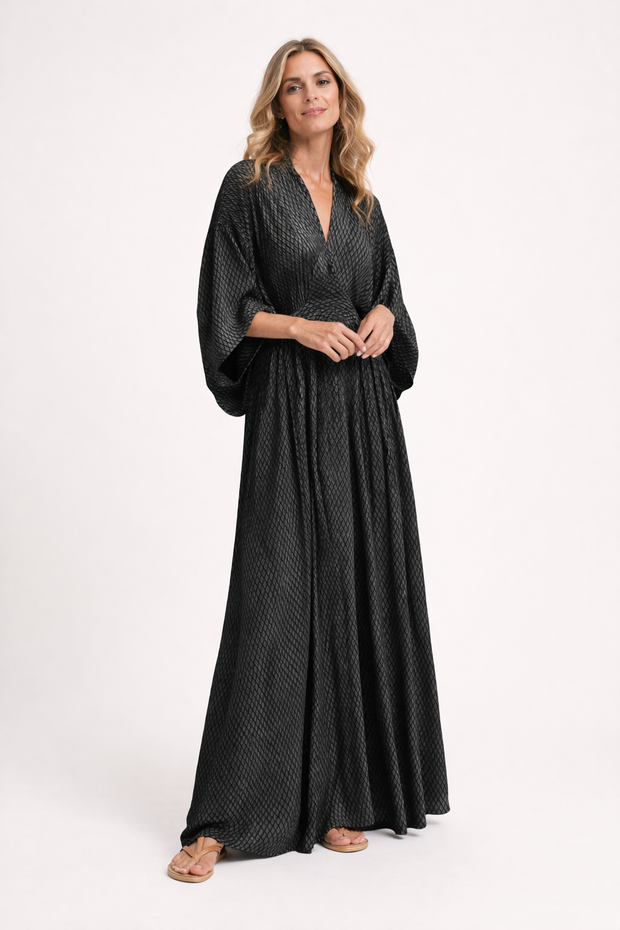 Woman wearing a black patterned dress on a white background