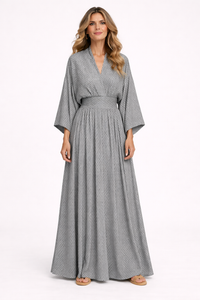 Woman wearing a long gray dress with a white background