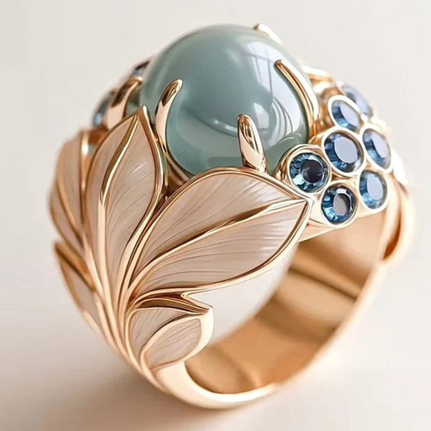 Exotischer Goldblatt-Ring Mit Grünlich Schimmerndem Stein Und Blattmotiv Mit Blauen Cabochon-Steinen Ishani