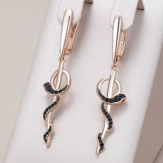 Elegante Serpentin-Ohrringe In Schwarz Mit Schwarzen Steinen Und Goldfarbenem Finish Noor